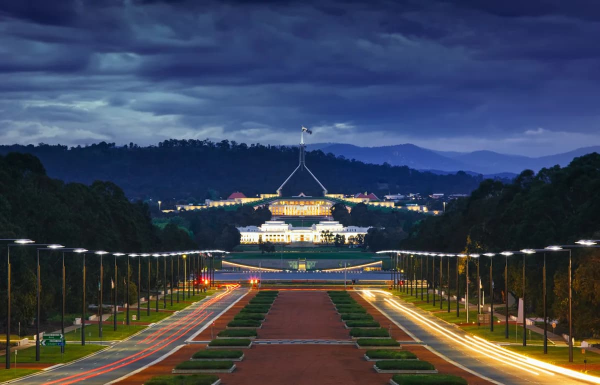 Canberra's ceremonial avenue and Parliament House at dusk.