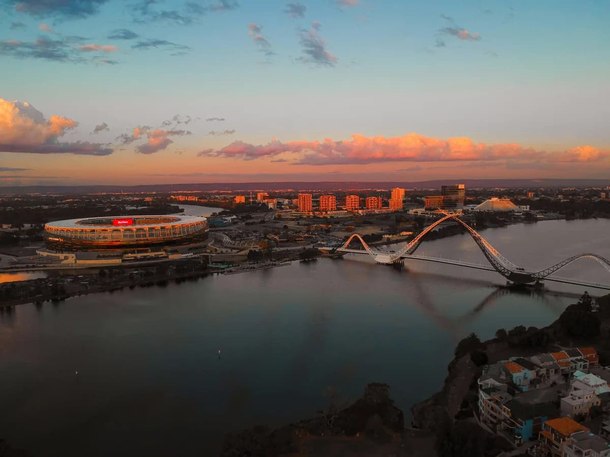 Perth's river, pedestrian bridge and stadium at sunset.