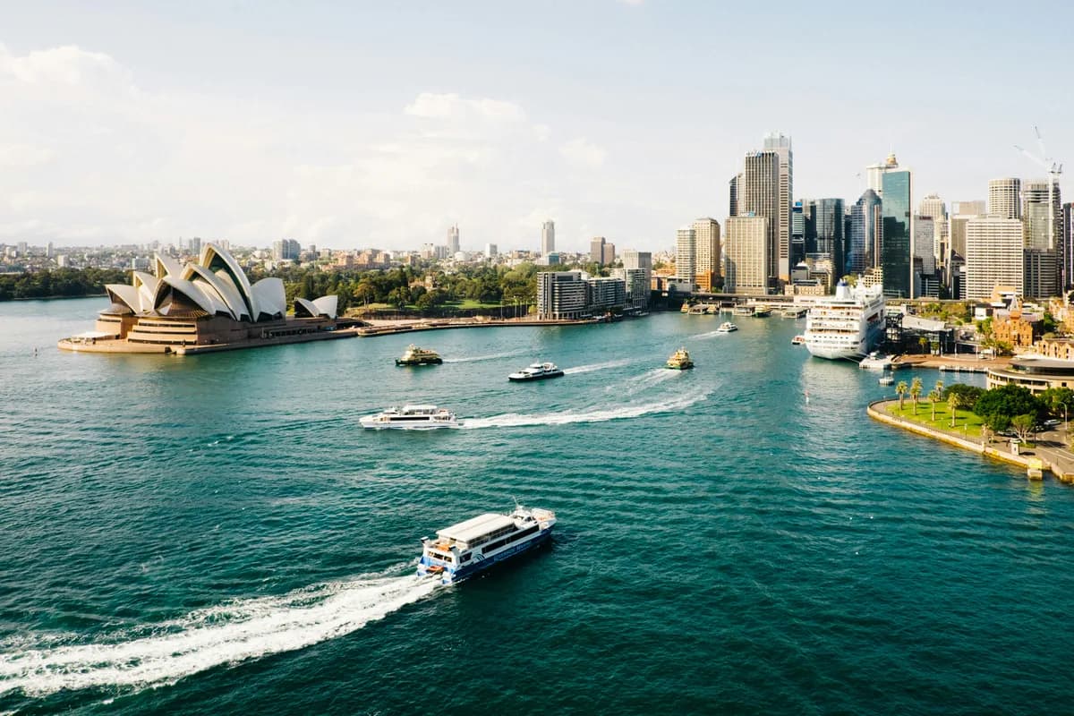 Sydney Opera House and city skyline beside the harbour.